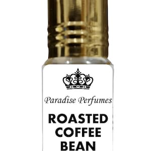 Puede incluir: Una pequeña botella de vidrio con una tapa dorada y una etiqueta blanca. La etiqueta tiene una corona negra y el texto "Paradise Perfumes Roasted Coffee Bean".