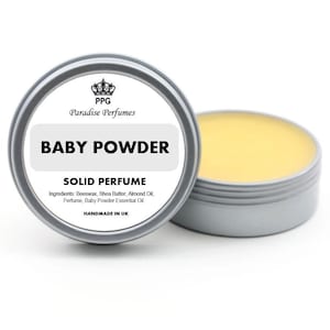 Könnte beinhalten: Eine silberne Dose mit einem weißen Etikett, auf dem steht: "PPG Paradise Perfumes Baby Powder Solid Perfume Ingredients: Beeswax, Shea Butter, Almond Oil, Perfume, Baby Powder Essential Oil. Handmade in UK."
