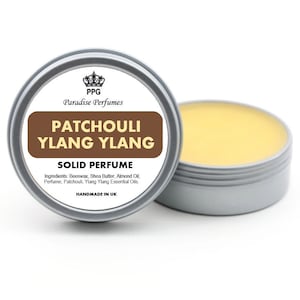 Op de afbeelding: Een zilveren blik met een bruin etiket waarop staat "PPG Paradise Perfumes Patchouli Ylang Ylang Solid Perfume" en de ingrediënten worden vermeld: Bijenwas, shea butter, amandel olie, parfum, patchouli, essentiële oliën van ylang-ylang. Het etiket vermeldt ook "Handgemaakt in het Verenigd Koninkrijk".