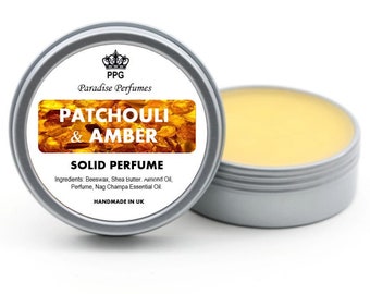 Może przedstawiać: Srebrny pojemnik z żółtą pokrywką zawierający stały perfum. Etykieta zawiera napis "PPG Paradise Perfumes Patchouli & Amber Solid Perfume Ingredients: Beeswax, Shea Butter, Almond Oil, Perfume, Nag Champa Essential Oil. Handmade in UK."