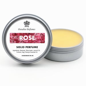 Może przedstawiać: Srebrny pojemnik z białą etykietą, na której widnieje napis "PPG Paradise Perfumes ROSE SOLID PERFUME Ingredients: Beeswax, Shea Butter, Almond Oil, Perfume, Nag Champa Essential Oil. HANDMADE IN UK". Pojemnik zawiera żółty stały perfum.