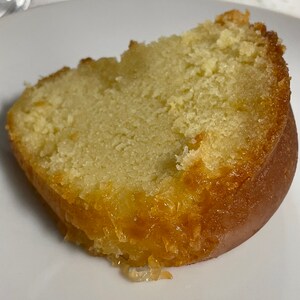 May include: A slice of yellow cake with a glazed, golden brown exterior. The cake is moist and has a crumbly texture.