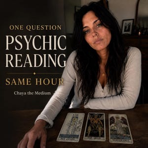 May include: A person with long dark hair wearing a cream-colored long-sleeve shirt sits behind a wooden table with three tarot cards: Ace of Cups, The Devil, and Temperance. Text reads: ONE QUESTION PSYCHIC READING SAME HOUR Chaya the Medium.