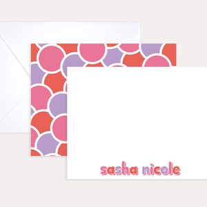 May include: A white card with a pink and purple circle pattern border. The text "sasha nicole" is printed in pink and purple letters at the bottom of the card.