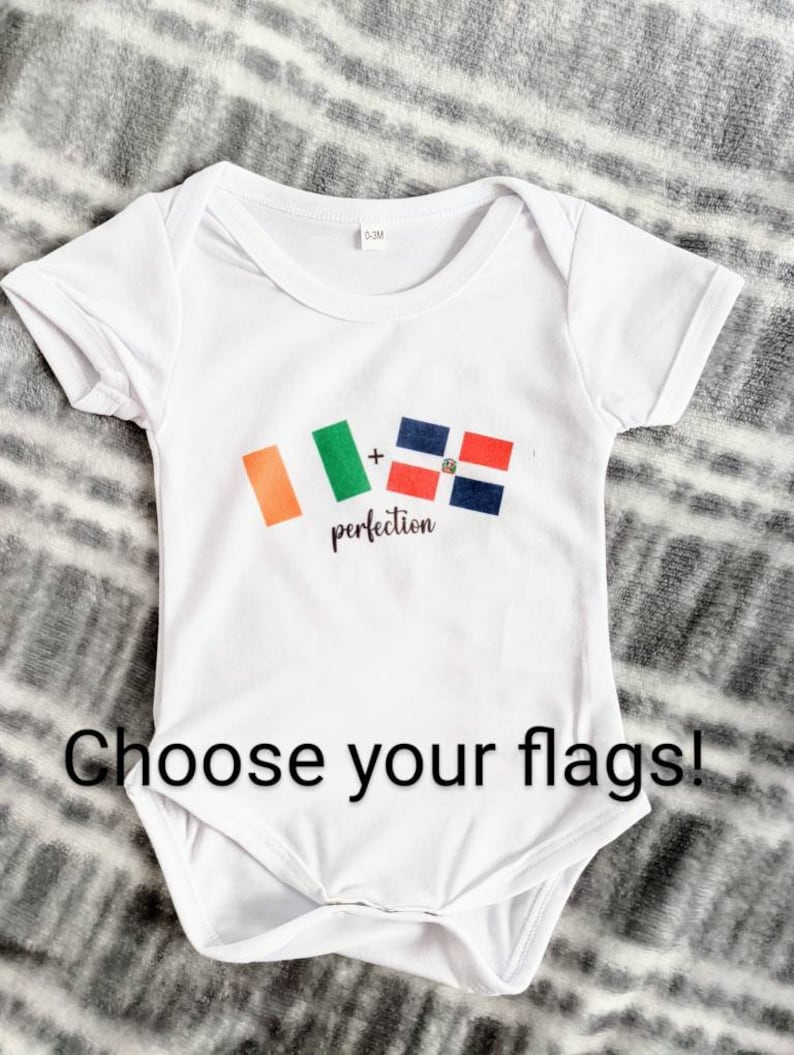 May include: White baby onesie with the flags of Ireland and the Dominican Republic printed on it. The text "+" and "perfection" are printed below the flags.