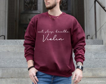 May include: Burgundy sweatshirt with the text "eat, sleep, breathe Violin" in white.