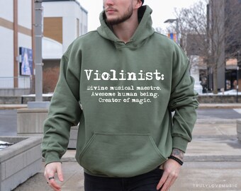 May include: A green hooded sweatshirt with the text "Violinist: Divine musical maestro. Awesome human being. Creator of magic." printed in white on the front.