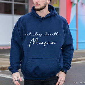 May include: A navy blue hoodie with a white graphic that says "eat, sleep, breathe music".