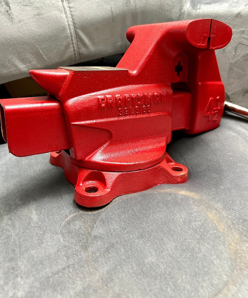 May include: A red Craftsman 4 1/2 inch bench vise with a cast iron base and a swivel jaw. The vise has a model number of 88168.