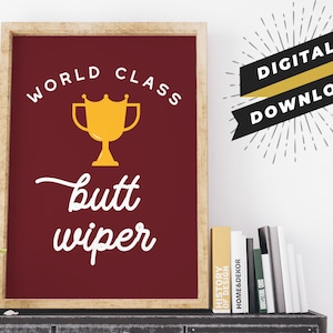 May include: A digital download of a printable poster with a gold trophy and the text "World Class Butt Wiper" on a maroon background.