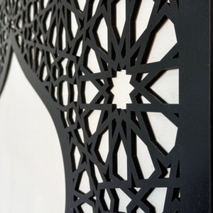 May include: Black geometric pattern cut out of a white surface. The pattern is intricate and detailed, creating a beautiful and modern design.