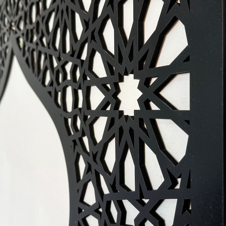 May include: Black geometric pattern cut out of a white surface. The pattern is intricate and detailed, creating a beautiful and modern design.