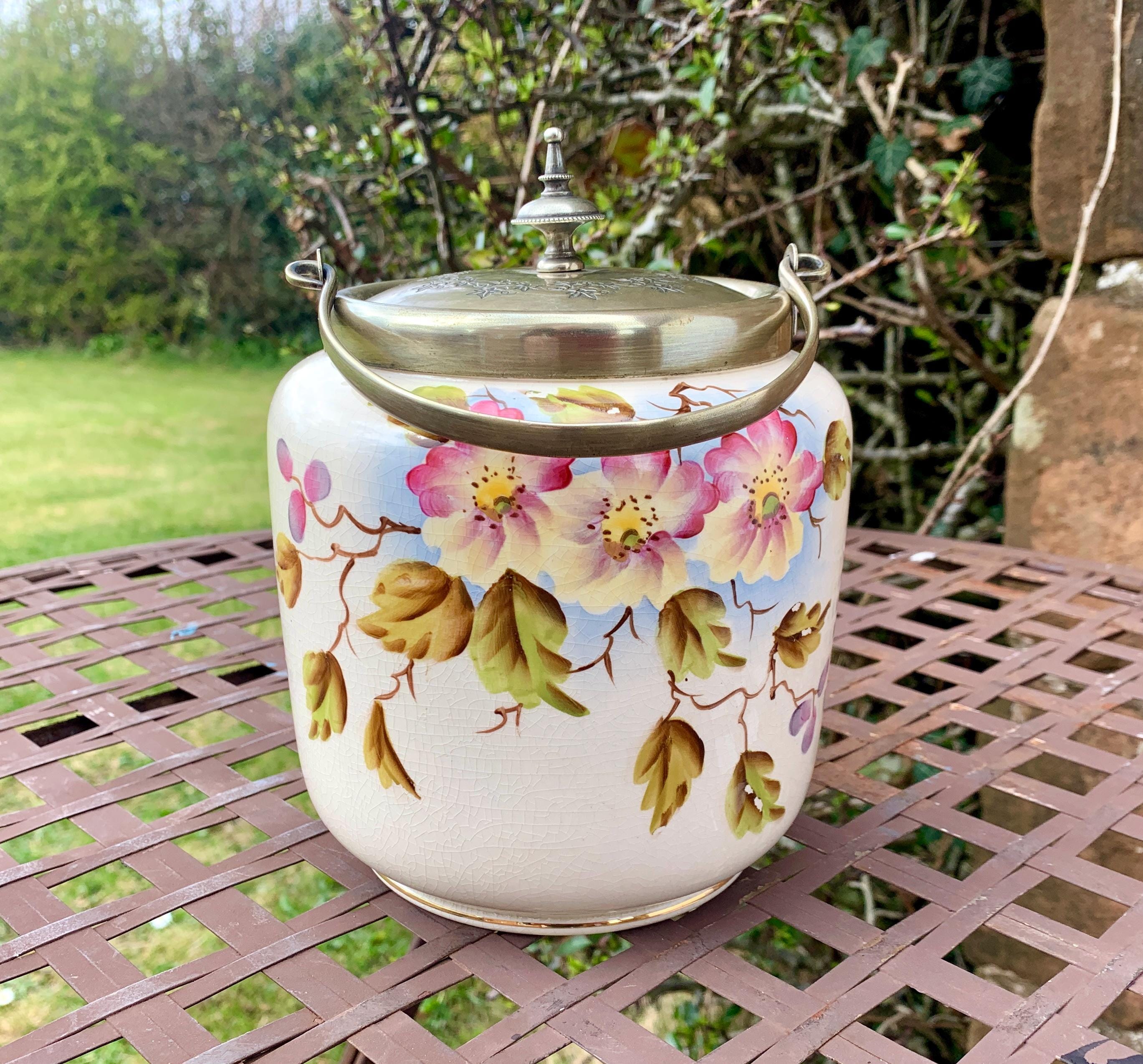 Contenedor vintage inglés para guardar galletas o bizcochos con decoración floral y foliada pintada a mano.
