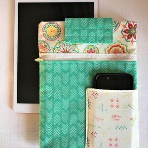 May include: A green and white fabric tablet case with a zippered pocket and a separate phone pocket. The phone pocket has a white fabric with a repeating pattern of red hearts, needles, and the text "I love my stash".