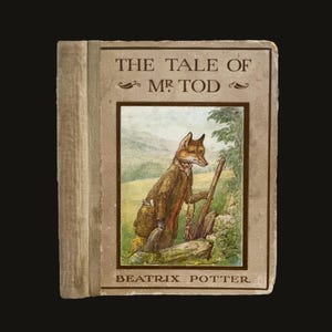 May include: A vintage hardcover book titled "The Tale of Mr. Tod" by Beatrix Potter. The cover features an illustration of a fox in a brown coat holding a wooden staff. The book has a beige cover and spine.
