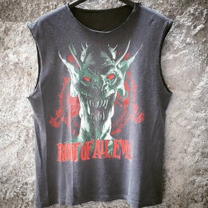 Può includere: Maglietta nera senza maniche con una grafica verde e rossa di un mostro con il testo "Root of All Evil" stampato sul davanti.