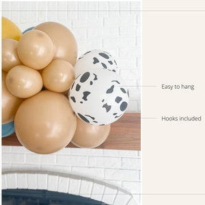May include: A collection of balloons in various sizes and colors, including tan and white with black spots. The balloons are arranged together, with the text "Easy to hang" and "Hooks included" visible.
