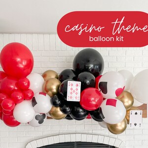 May include: A casino themed balloon arch kit with red, black, white, and gold balloons. The balloons are arranged in a cascading arch shape and include playing card cutouts with hearts, spades, diamonds, and clubs.