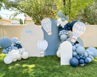 Könnte beinhalten: Ein blauer und weißer Ballonbogen mit Heißluftballon-Ausschnitten und einem Schild mit der Aufschrift "ONE derful".