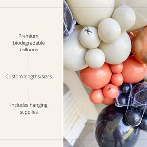 May include: A balloon garland in a Halloween theme, featuring a mix of colors including black, orange, cream, and gold. The balloons are arranged in a cluster and decorated with spiderwebs and small plastic spiders. The text on the left says "Premium, biodegradable balloons", "Custom lengths/sizes", and "Includes hanging supplies".
