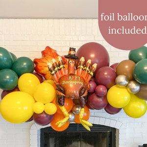 May include: A Thanksgiving balloon garland with a turkey foil balloon, green, brown, and yellow latex balloons, and the text "Happy Thanksgiving". Foil balloons are included.