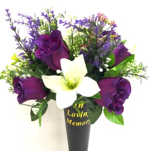 May include: A purple and white artificial flower arrangement in a black cone vase with the text "In Loving Memory".