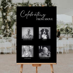 Könnte beinhalten: Ein schwarzes Schild auf einer Holzstaffelei mit den Worten "Celebrating From Above" in eleganter Schrift. Das Schild zeigt vier Schwarz-Weiß-Fotos von geliebten Menschen, darunter ein Hund namens Marley. Das Schild wird bei einer Outdoor-Veranstaltung ausgestellt.