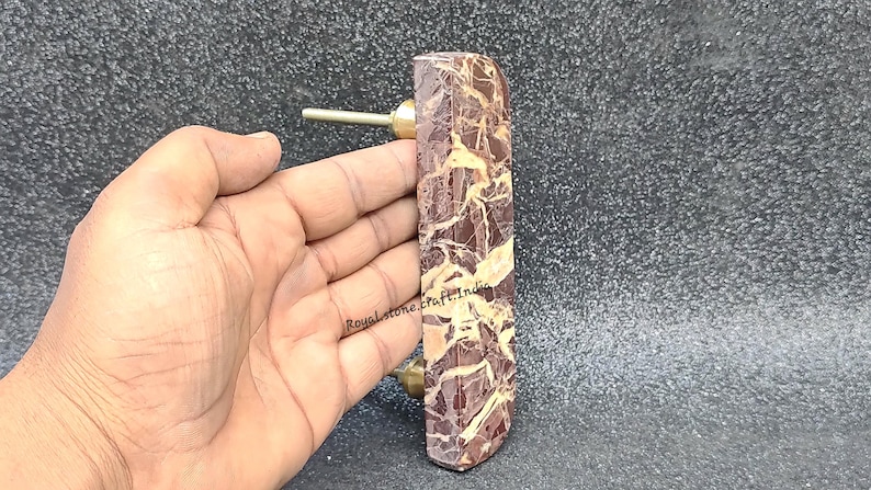 Handheld half moon marble cabinet handle showing real size, natural brown marble with gold veining and brass screw fittings