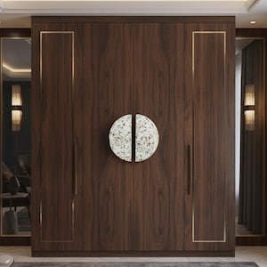 Puede incluir: Un armario grande de madera oscura con un tirador decorativo circular. El armario tiene un borde dorado y está flanqueado por espejos. La habitación tiene un diseño moderno con colores neutros y un toque de azul.