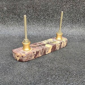 Back view of straight marble door handle with dual brass screw fittings, natural brown marble showing installation hardware and solid stone construction
