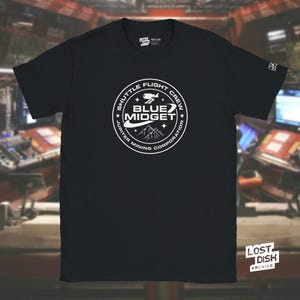 May include: Black t-shirt with a white circular graphic featuring the text "Shuttle Flight Crew Blue Midget Jupiter Mining Corporation." The shirt also has the text "Lost Dish Archive" and "Lost Medium" printed on it.