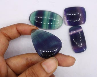 May include: Four polished fluorite stones in shades of green, purple, and blue. The stones are smooth and have a glossy finish.