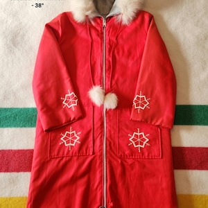 May include: A vibrant red winter coat featuring a white fur-trimmed hood and snowflake embroidery. The coat has a zip closure, two front pockets, and white pom-poms. Shoulder to front hem is 96.5 cm.