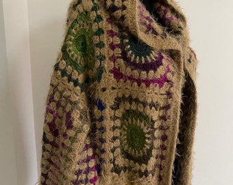 May include: A brown crocheted cardigan with a hood, featuring colorful circular patterns in shades of green, pink, purple, and blue.