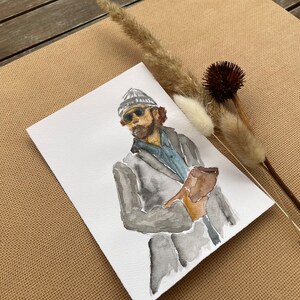 Könnte beinhalten: Aquarellmalerei einer Person mit einer grauen Mütze und Sonnenbrille, die ein braunes, ledergebundenes Buch hält. Die Person trägt eine graue Jacke und ein blaues Hemd.