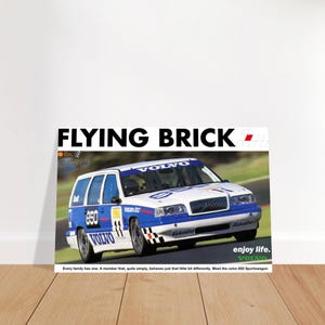 Könnte beinhalten: Ein Poster mit einem weißen und blauen Volvo 850 Sportswagon-Rennwagen mit dem Text "FLYING BRICK" oben. Das Auto hat die Nummer "850" an der Seite und den Text "enjoy life. VOLVO" unten.