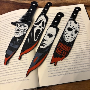 May include: Four knife-shaped bookmarks featuring horror movie characters. The first shows Freddy Krueger, the second Ghostface, the third Michael Myers, and the fourth Jason Voorhees with the text FRIDAY THE 13TH in orange letters on the blade.