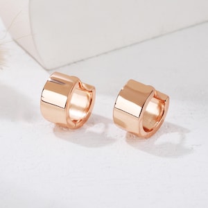 Peut inclure: Une paire de boucles d'oreilles créoles en or rose de forme carrée. Les boucles d'oreilles sont simples et élégantes.