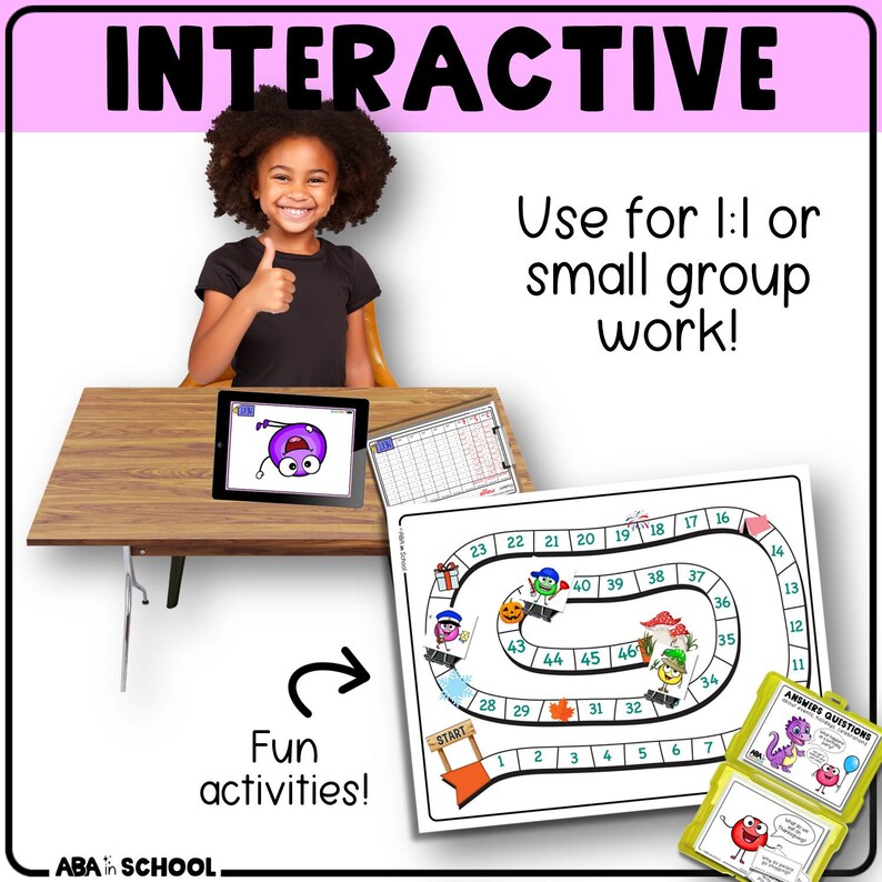 May include: An educational image with the word "INTERACTIVE" at the top. A young girl gives a thumbs up. A board game, tablet, and flashcards are on a wooden desk. The text says "Use for 1:1 or small group work!" and "Fun activities!"