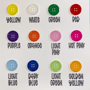 May include: A collection of colorful buttons arranged on a white background. The buttons are in various colors, including yellow, white, green, red, purple, orange, light pink, hot pink, light blue, dark blue, light green, and golden yellow. Each button has four holes, and the color names are written below each button.