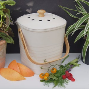 May include: White ceramic compost bin with a wooden handle and lid. The bin has a label that says "bioBitz".