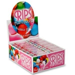 May include: A display box of RIPS Flavours bubble gum. The box is pink and white with the brand name and product description printed on the sides. The top of the box features a colourful graphic of bubble gum balls. The box is filled with individual packs of bubble gum.