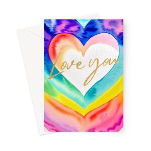 May include: A watercolor greeting card with a rainbow heart design and the words "Love you" in gold glitter script. The card is paired with a white envelope, perfect for sending a heartfelt message.