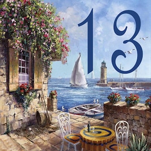 May include: A painting depicting a seaside scene with a house, a sailboat, a lighthouse, and a table with two chairs. The number "13" is painted in blue in the top right corner of the image.