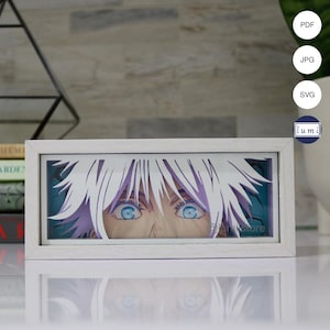 Pode incluir: Uma obra de arte de papel recortado enquadrada em branco que apresenta um close-up do rosto de um personagem com olhos azuis e cabelo branco. Os olhos do personagem estão olhando diretamente para o espectador.