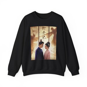 Könnte beinhalten: Schwarzes Sweatshirt mit einem Filmplakat-Design. Das Poster zeigt einen Mann und eine Frau in traditioneller asiatischer Kleidung mit Text in asiatischer Sprache. Der Hintergrund hat einen Sepia-Ton.