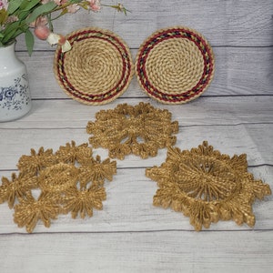 May include: Four woven straw coasters. Two round coasters with red and green trim. Two snowflake-shaped coasters.