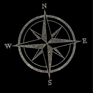 May include: A silver compass with a black background. The compass has a star-shaped design with points extending to the north, south, east, and west.