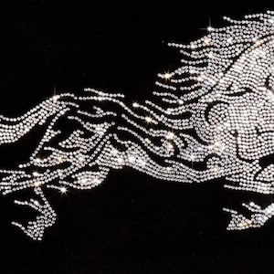 May include: A black background with a white horse silhouette made of rhinestones. The horse is in a running pose with its mane flowing behind it.