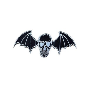 Peut inclure: Patch brodé noir et blanc d'un crâne avec des ailes de chauve-souris.